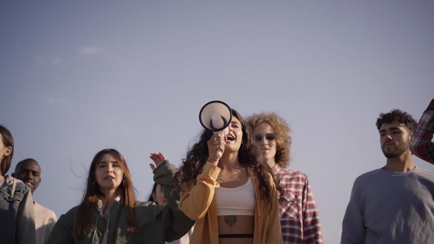 At the demonstration a woman shouting on megaphone. Young people protest for democracy. High quality FullHD footage