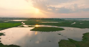 Aerial view video landscape Agricultural area in rural Thailand with many ponds reflecting the beautiful sun in the evening. Filmed with high quality film cameras. DCI 4K ProRes422