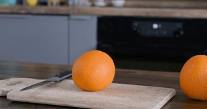 Orange oranges on the table in the kitchen, the video camera moves in a circle