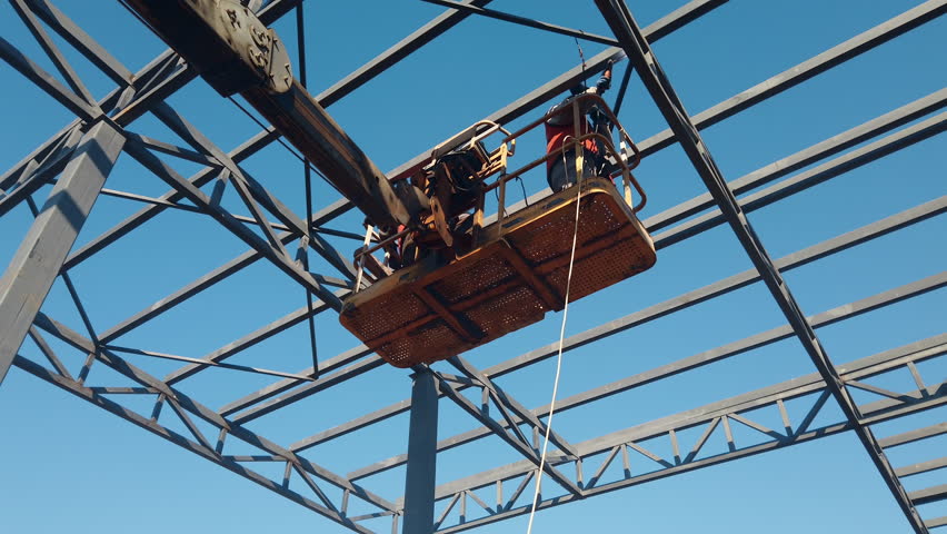Construction workers on high cherry-picker welding the metal frames on construction site Royalty-Free Stock Footage #1109006459