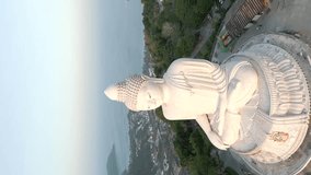 Vertical video. Aerial view of the Buddha statue on the hilltop of Phuket island at sunrise, Thailand.