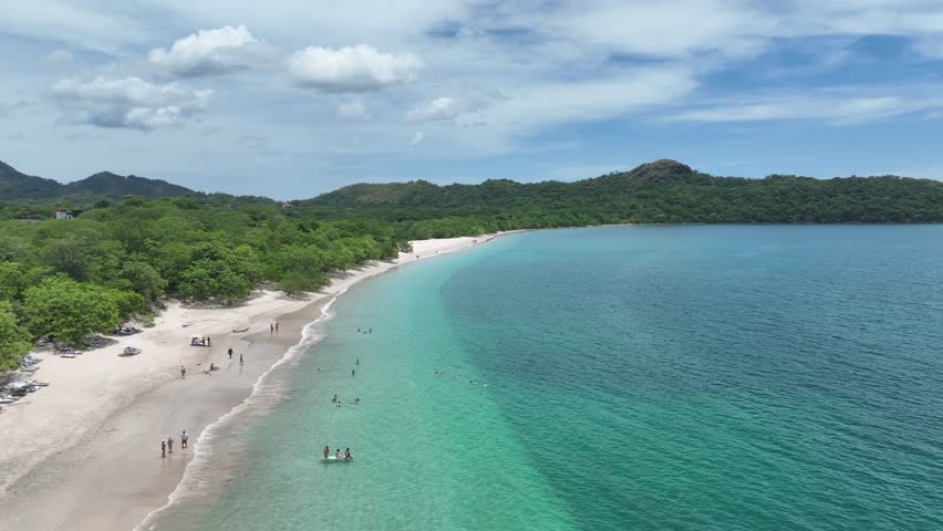 Playa Conchal, in Guanacaste, Costa Rica, is a stunning beach known for its unique seashell-covered shores, crystal-clear waters, and lush surroundings, perfect for a tropical escape.