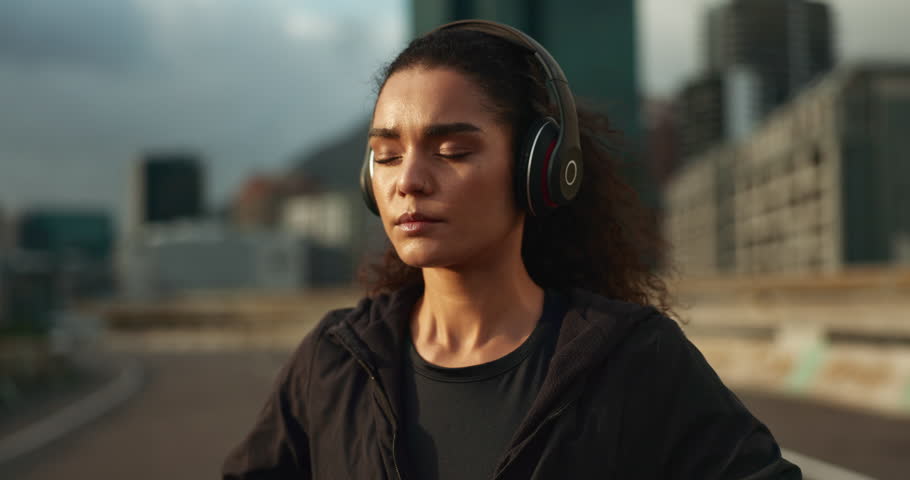 Headphones, watch and woman athlete in the city for race, marathon or competition training. Breathe, sports and young female runner listen to music on break for running cardio workout in town. Royalty-Free Stock Footage #1109020013