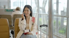 Smiling young asian woman sitting in waiting room and talking over smartphone with friend or family. Beautiful female traveller talking on cell phone at airport lounge. Woman on phone. - Powered by Shutterstock - Get 15% off with code: PIKWIZARD15