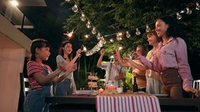 Family and friends gathering celebrating outdoor new year party and play festival sparklers together having enjoy at home. Big family multi-ethnic celebrating outdoors party at garden. - Powered by Shutterstock - Get 15% off with code: PIKWIZARD15