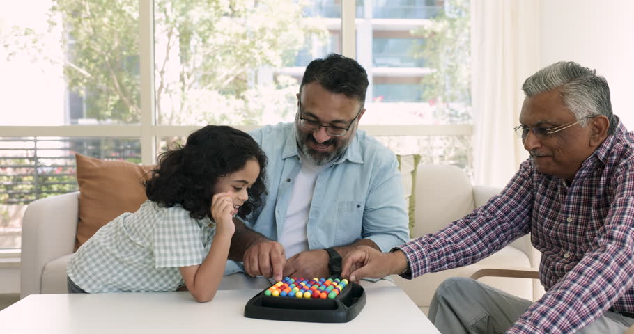 Loving multi-generational Indian family sit at table play rainbow balls boardgame with preschooler boy, enjoy IQ board game to improve children cognition, boost concentration. Intellectual activity Royalty-Free Stock Footage #1109028239