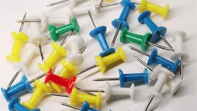 Colorful push pins rotating on white background. Drawing pins for marking