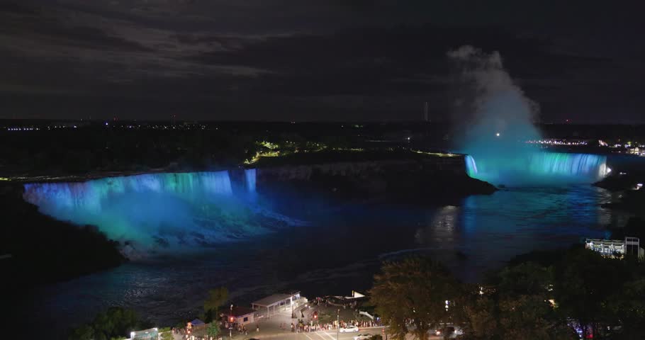Elevated view of illuminated American and Horseshoe falls with rapid changing colors at night in Niagara Falls, Canada