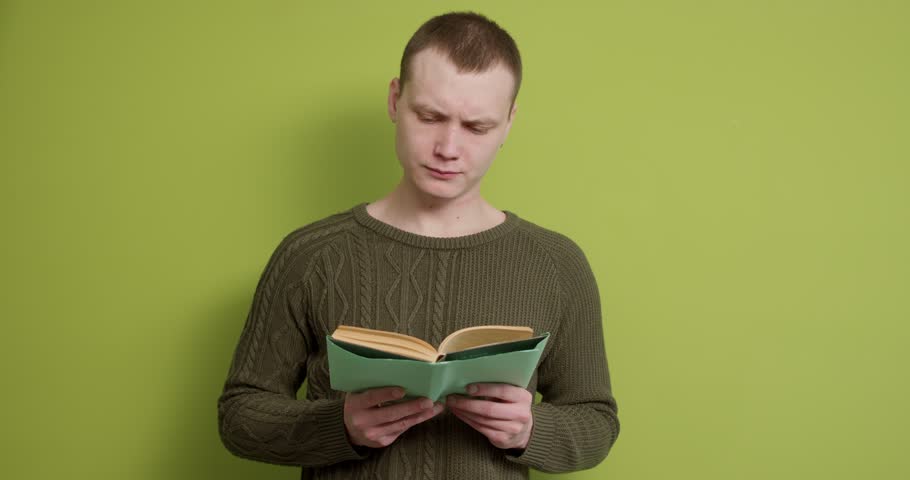 Young man student studying learning lessons, reading book, preparing for exam Slow motion Education guy concentrated on reading process, male is interested in learning information Hobby, lifestyle