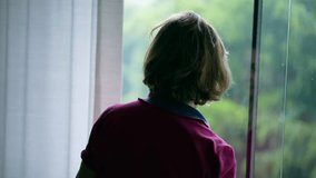 Pensive Senior woman standing by window looking out at view during rainy day. Contemplative elderly retired lady at home while raining outside, staring at rain - Powered by Shutterstock - Get 15% off with code: PIKWIZARD15