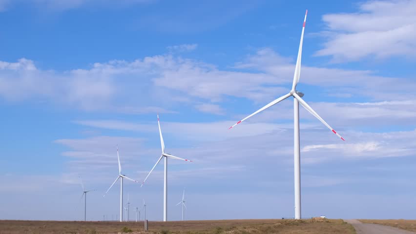 Fleet of power generators in motion. The blades of the wind farm rotate against the sky. The concept of extracting electricity from renewable sources. Wind turbine to generate electricity. Royalty-Free Stock Footage #1109033485