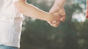 happy family father and daughter hold hands close up. Dad and baby girl hands together at sunset. Father Day. Dad and daughter are holding hands. A father extended a helping hand to his daughter child - Powered by Shutterstock - Get 15% off with code: PIKWIZARD15