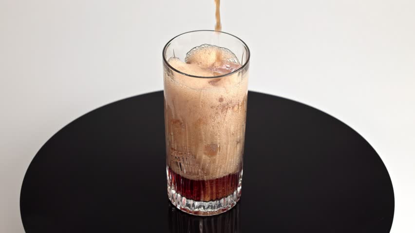 Close up view of pouring of soda drink into glass with ice cubes on rotating disc. Slow motion. | Shutterstock HD Video #1109035747