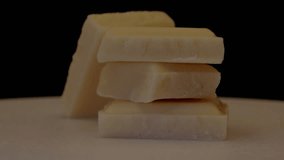 rotation of pieces of white chocolate bar on a tray seen close up