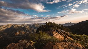 Timelapse mountains. Cinematic sunset filmed on top of mountain. Amirsoy. Diverse landscape of head of mountains, rocky and green peaks under sunset sky with clouds. Grace and calm, meditative mood