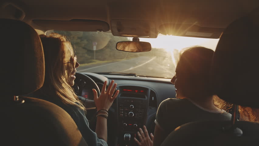 Two girls women are sitting in a car and listening to music. They very emotionally dancing and smiling. Friends spend joyful time together at sunset. Roadtrip vacation concept. Friendship relationship Royalty-Free Stock Footage #1109048371