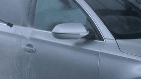 Washing luxury silver car on touchless car wash. Washing sedan car with foam self-service and high pressure water. Winter cleaning in car wash. Cleanliness and order in urban environment Man hands - Powered by Shutterstock - Get 15% off with code: PIKWIZARD15