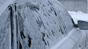 Washing luxury silver car on touchless car wash. Washing sedan car with foam self-service and high pressure water. Winter cleaning in car wash. Cleanliness and order in urban environment Man hands - Powered by Shutterstock - Get 15% off with code: PIKWIZARD15