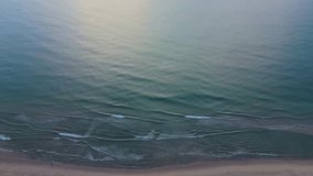 A pristine, uninhabited beach scene filmed from the air with sand, sea, and waves. Ocean and travel background concept.