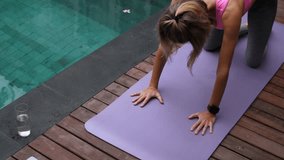 Mid adult woman doing yoga near the swimming pool at daytime - Powered by Shutterstock - Get 15% off with code: PIKWIZARD15