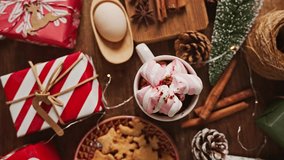 Pastel Christmas decoration on the table with flickering bulbs and hot drink with marshmallow - Powered by Shutterstock - Get 15% off with code: PIKWIZARD15