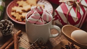 Pastel Christmas decoration on the table with flickering bulbs and hot drink with marshmallow - Powered by Shutterstock - Get 15% off with code: PIKWIZARD15