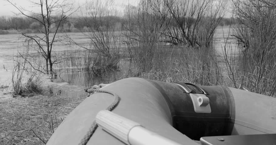 Group of Men Dressed As British And American Soldiers Of USA Infantry Of World War II dragging a boat to the water In Autumn Spring Day. Black And White Colors