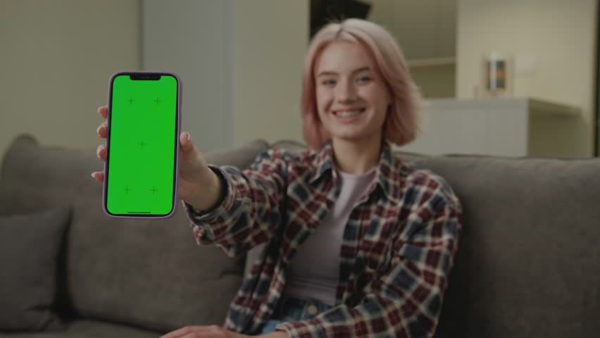 Woman Holding Green Screen Smartphone At Camera. Smiling 20s female shows cell phone with chroma key screen at camera. | Shutterstock HD Video #1109069877