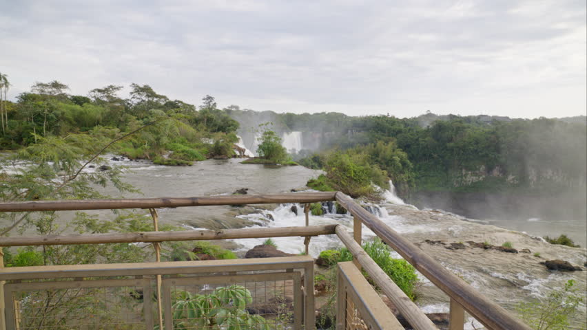 A male individual marveling at the descending waterfalls with admiration.