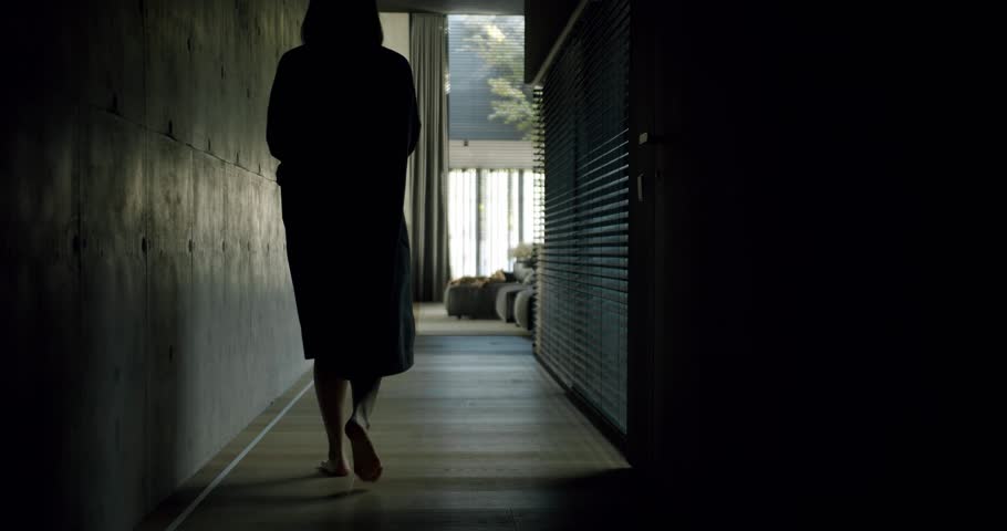 Back view on woman go barefoot in room and led light strip turns on on floor. Modern integrated illumination system with motion sensor at stylish apartment Royalty-Free Stock Footage #1109072393