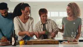 Group of friends at home in kitchen adding toppings to homemade pizzas for party together - Powered by Shutterstock - Get 15% off with code: PIKWIZARD15