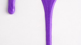 Liquid drops of bright shiny purple paint flowing on the white surface. Purple nail polish. Sample of makeup in lavender color - Powered by Shutterstock - Get 15% off with code: PIKWIZARD15