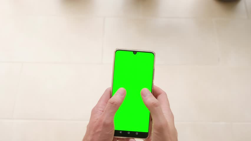 A man holds a phone in his hands with a green screen, top view. Slow motion. | Shutterstock HD Video #1109075907