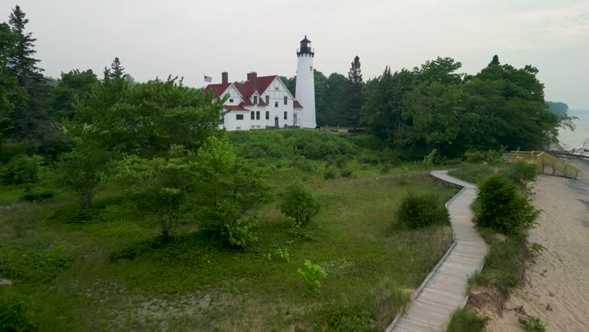 Aerial view ascending approach of Point Iriquois Lighthouse, Lake Superior, Michigan