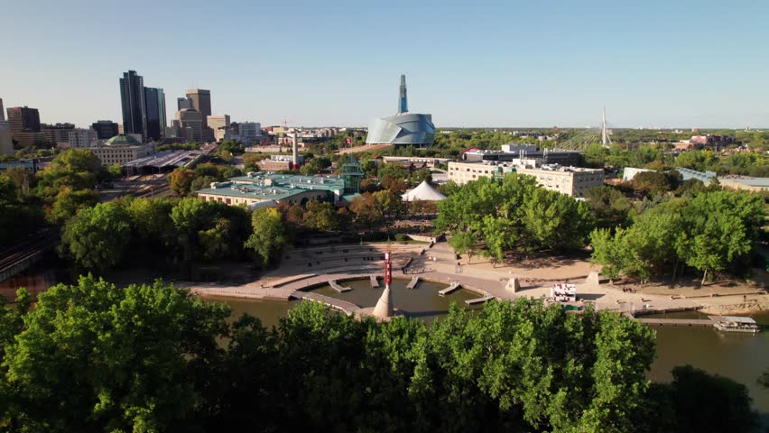Gorgeous cinematic aerial of downtown Winnipeg, MB, Canada. Forks Waterfront and Assiniboine River in foreground.