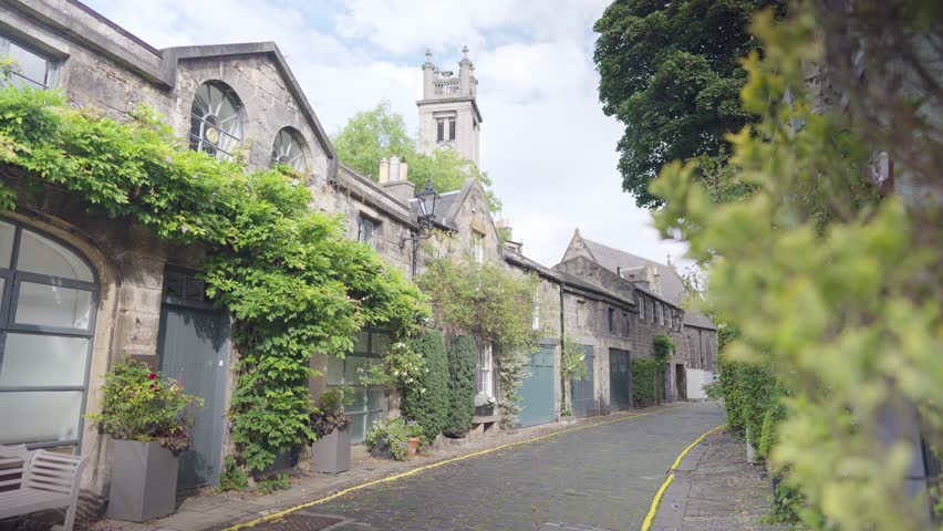 Scenic walking route along Circus Lane in Edinburgh, with a clock tower in the background. Summer 2022.
