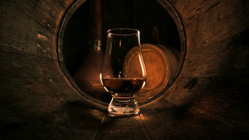 A glass of whiskey in old oak barrel. Copper alambic on background. Traditional alcohol distillery concept Royalty-Free Stock Footage #1109089133