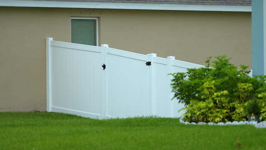 Vinyl plank fence in Florida backyard. White plastic fencing for grounds protection and privacy Royalty-Free Stock Footage #1109089289