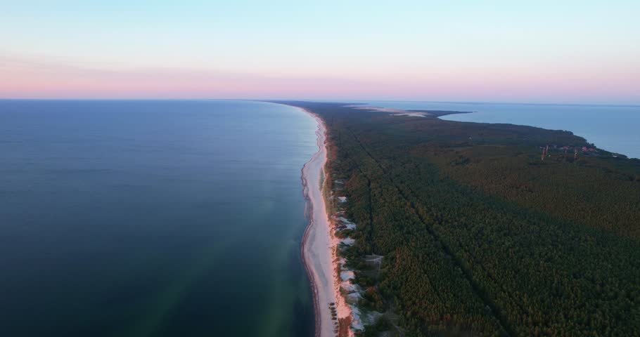 Curonian Spit National Park at sunset, aerial shot. A narrow and long sandy strip of land separating the Curonian Lagoon from the Baltic Sea. Forest and sea. Drone view Royalty-Free Stock Footage #1109090015