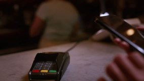 An old woman pays for purchases, contactless with a smartphone, NFC technology. Senior female puts the phone to the pos terminal in a cafe or restaurant. The concept of modern technologies - Powered by Shutterstock - Get 15% off with code: PIKWIZARD15