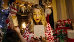 Authentic shot of happy woman receiving Christmas gift from her man. Gorgeous woman surprised and excited after opening golden gift box. Concept of winter holidays, romantic night, surprise excitement - Powered by Shutterstock - Get 15% off with code: PIKWIZARD15