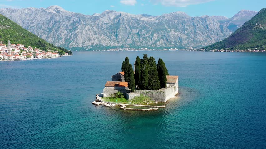 Saint George Island and Church of Our Lady of the Rocks in Perast, Montenegro. Our Lady of the Rock island and Church in Perast on shore of Boka Kotor bay (Boka Kotorska), Montenegro, Europe.  Royalty-Free Stock Footage #1109093739