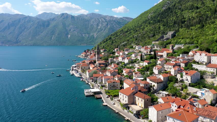 View of the historic town of Perast at famous Bay of Kotor on a beautiful sunny day with blue sky and clouds in summer, Montenegro. Historic city of Perast at Bay of Kotor in summer, Montenegro. Royalty-Free Stock Footage #1109093747