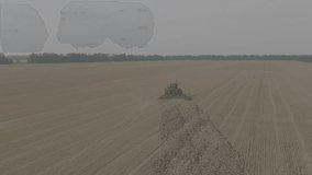 Disking the field. Big red Tractor cultivating land of Disc Harrow. Tractor at a disking of ground. Agriculture. Aerial view of tractor plowing the field. Slow motion, 10 bit ungraded D-LOG video