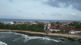 cinematic aerial footage as the camera gracefully moves around to reveal the renowned Galle Fort, an ancient fortress and iconic lighthouse landmark situated by the Indian Ocean in Galle, Sri Lanka