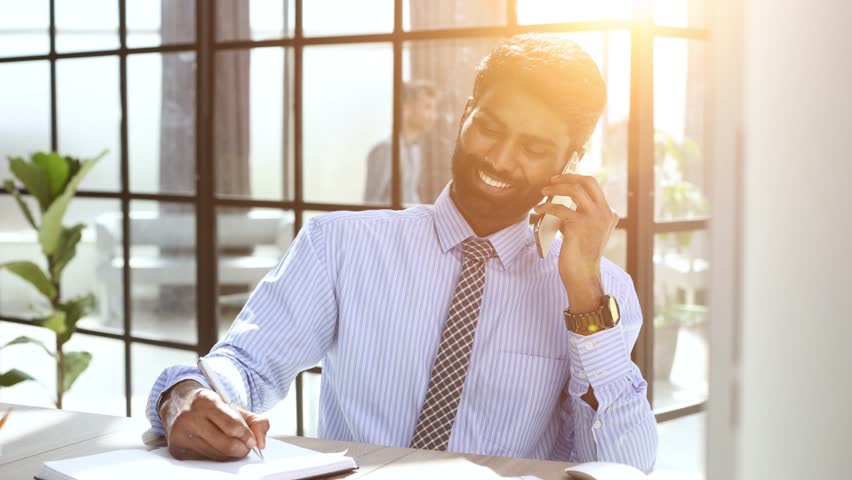 Businessman talking on phone with customers, male salesman working inside modern office building. | Shutterstock HD Video #1109096619