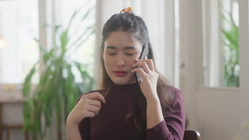 Happy young asian woman using mobile phone talking with friends on cell phone
 | Shutterstock HD Video #1109096907