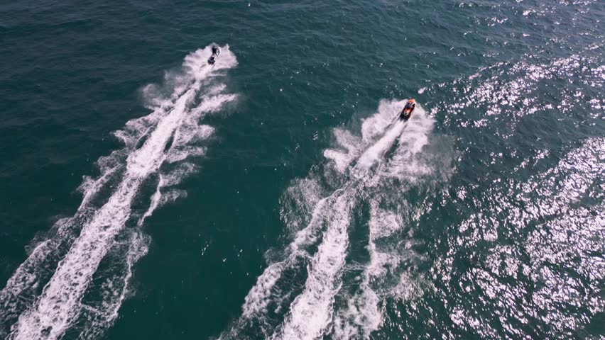 Aerial view of a personal watercraft speeding through the waves, creating a mesmerizing trail. Royalty-Free Stock Footage #1109098151