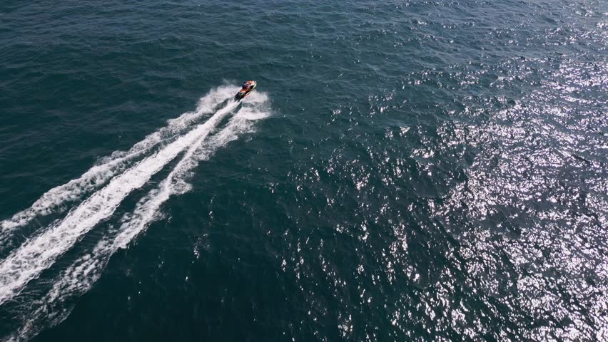 Aerial view of a personal watercraft speeding through the waves, creating a mesmerizing trail. Royalty-Free Stock Footage #1109098175