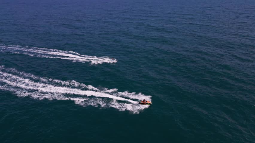 Aerial view of a personal watercraft speeding through the waves, creating a mesmerizing trail. Royalty-Free Stock Footage #1109098179
